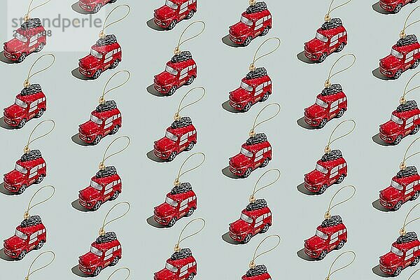 Gray green background pattern with Christmas or New Year symbol attribute objects and symbolic items concept. Small red English taxi car toy with ribbon  golden little toy fir tree.