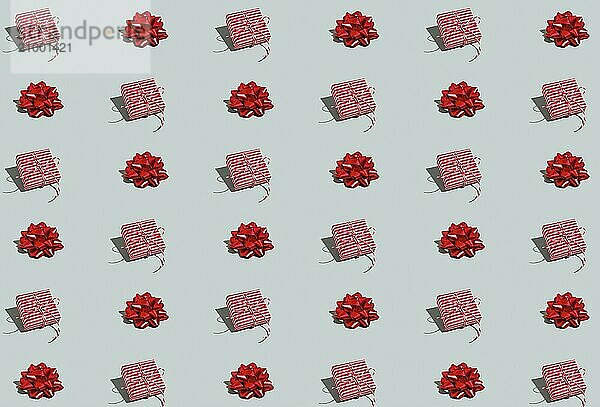 Gray green background pattern with Christmas  New Year symbol attribute objects and symbolic items concept. Pink little gift box present with ribbon  small red tied bow. Book cover  covering paper