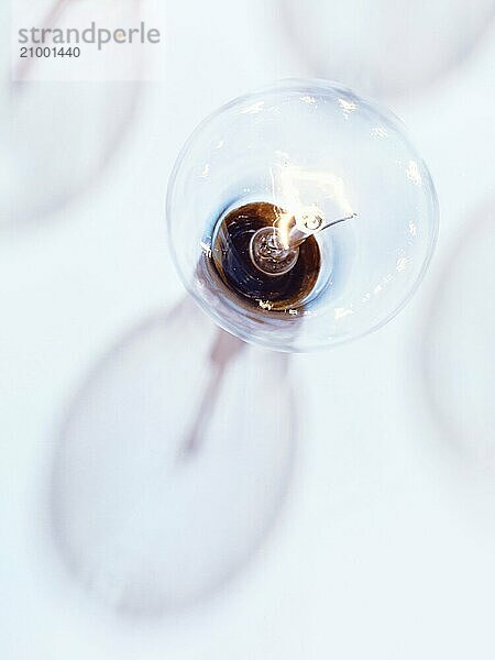 Incandescent tungsten light bulb with a shadow on light blue background