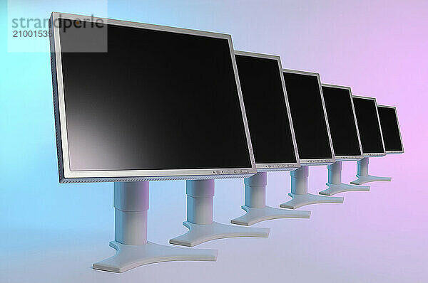 Row of computer LCD monitors with black blank displays on colored pink blue background