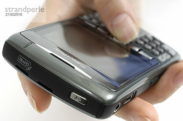 Strock photo of a Hand with BlackBerry 8310 Curve Smartphone Isolated silhouette on white background