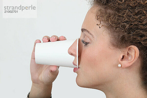 Woman drinking from a paper cup with her nose printed on it  Funny