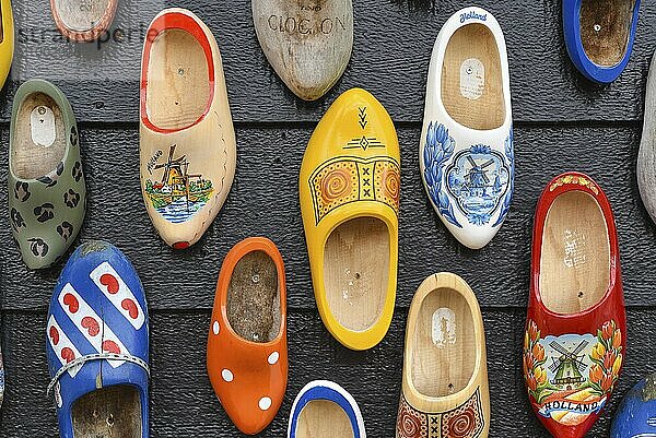 Koog aan de Zaan  Netherlands. July 2022. Colorful clogs against the background of a wooden wall. Popular souvenirs. Traditions of Holland. Close up. Selective focus