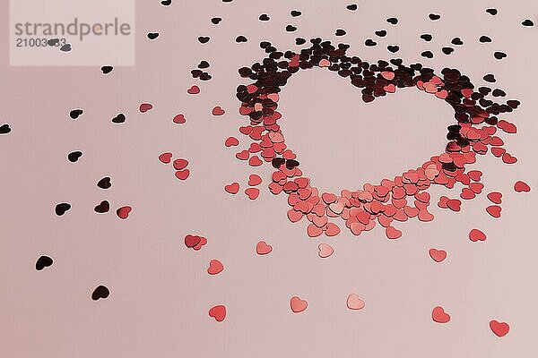 Red heart glitters on the pink background.