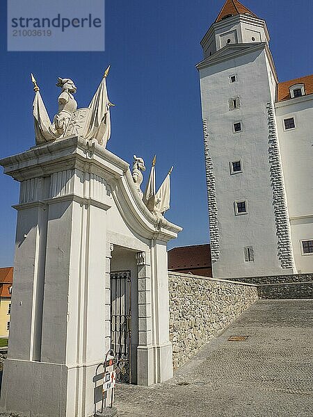 View of a white archway and a castle in the background with towers and blue sky  bratislava  slovakia