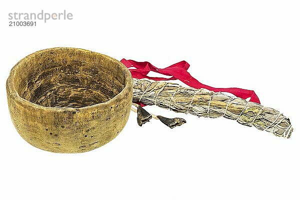 Indian wooden bowl with dried sage plait decorated with red ribbons and deer shells on a white background