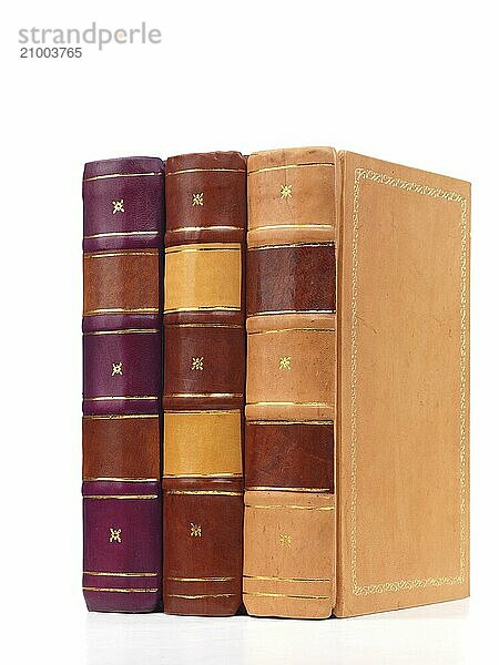 Three hardcover leather bound books isolated on white background