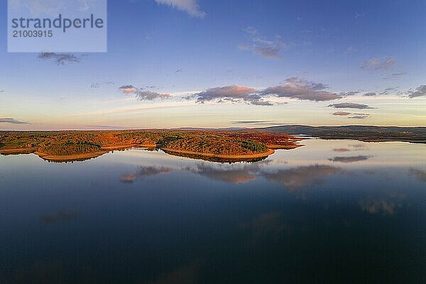 Drone aerial view of a lake reservoir of a dam with perfect reflection on the water of the sunset in Sabugal  Portugal  Europe