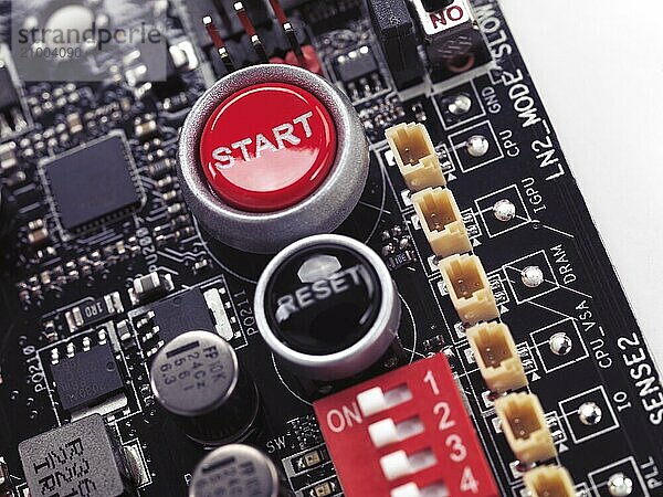 Start and Reset buttons on computer motherboard closeup on white background