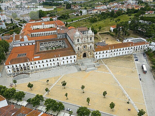 An aerial view of a historic monastery with red roofs in a town with surrounding landscape  Aerial view  Mosteiro de Alcobaça Monastery  Alcobaca  Oeste  Centro  Portugal  Europe