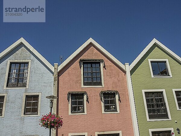 Three colourful house facades with windows and flower decorations under a clear sky  trelleborg  sweden  baltic sea  scandinavia