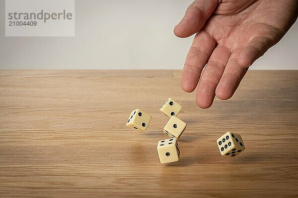 Hand throwing dice in front of a dark background