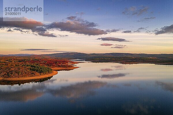 Drone aerial view of a lake reservoir of a dam with perfect reflection on the water of the sunset in Sabugal  Portugal  Europe