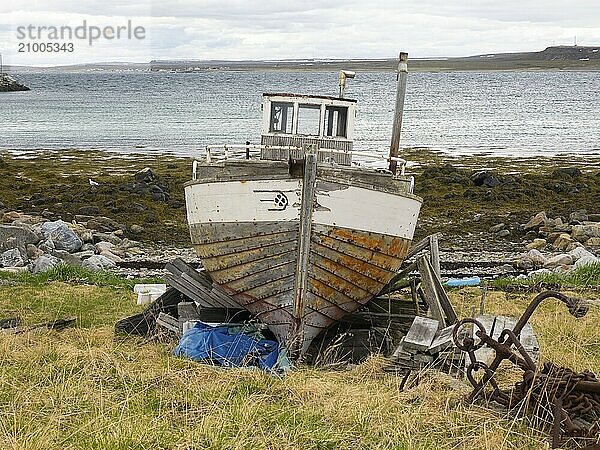 Derelict fishing boat on the shore of the Arctic Ocean  at the edge of the fishing village of Ekkeroy  May  Varangerfjord  Norway  Europe