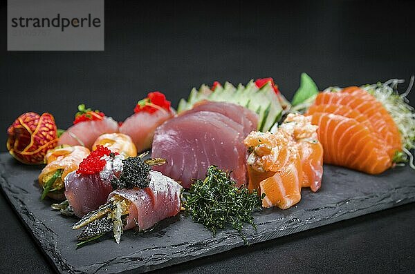 Sushi  traditional Japanese cuisine. Several delicious sushi on the decorated plate  black background. Group of sushi  Urakami  Nigori  Sushi jow  sashimi  tekamaki  etc