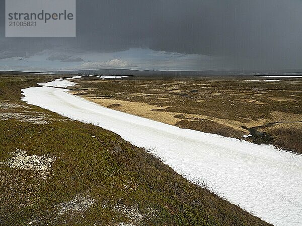 Rain clouds sweeping over tundra landscape  with snow remains in a small valley  Varanger National Park  Varanger Fjord  May  Norway  Europe