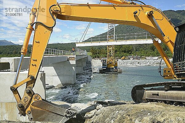 Builders construct a concrete bridge over a small river in Westland  New Zealand  Oceania