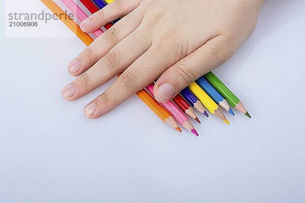 Hand holding color Pencils placed on a white background