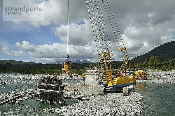 GREYMOUTH  NEW ZEALAND  DECEMBER 2013: Builders construct a concrete bridge over a small river in Westland  New Zealand  Oceania