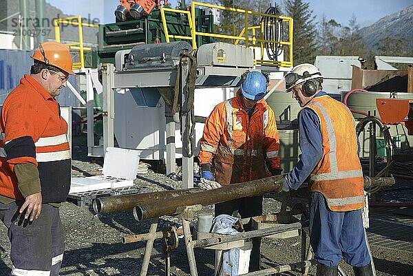 Drilling crewmen prepare to remove a core sample from a rig drilling near Greymouth  New Zealand  Oceania