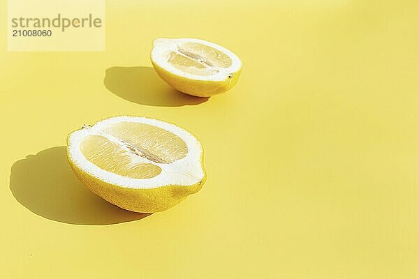 Two halved cuts of lemon with shadow on yellow background. Healthy eating  travel or vacation concept