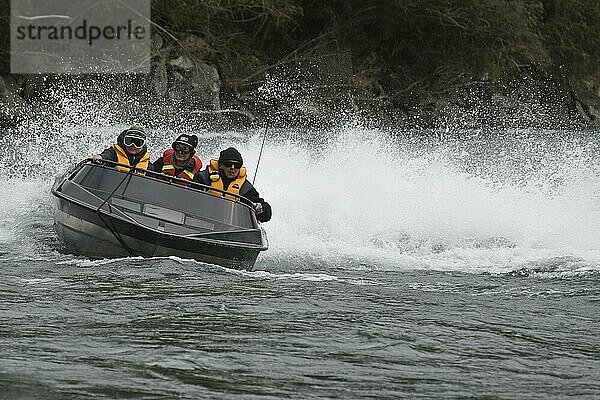 TARAMAKAU RIVER  WEST COAST  NEW ZEALAND  SEPTEMBER 3  2019: Three people power their jetboat up the Taramakau River