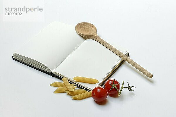 Notebook for recipes  cooking spoons  pasta and tomatoes