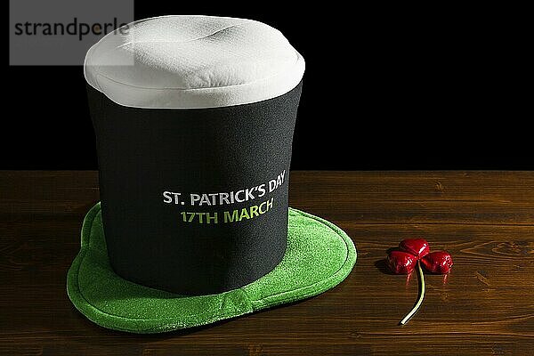 St Patrick day with hat and shamrock over a table and black background