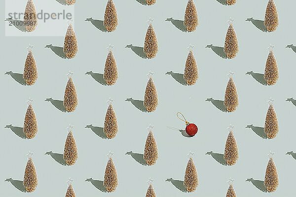 Gray green background pattern with Christmas or New Year symbol attribute objects and symbolic items concept. Golden little toy fir tree with shadow  red toy ball or sphere. Book cover  covering paper