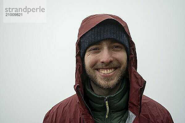 Young man with cap and rain jacket in foggy weather  smiling  portrait  Poás National Park  central highlands  Alajuela province  Costa Rica  Central America