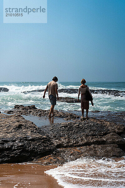 Happy friends walking on the beach.