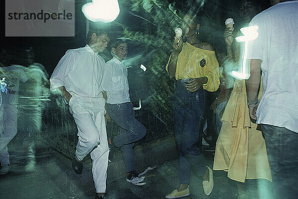 Teenagers hanging out on the street at night in Havana  Cuba.