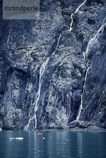 A rugged waterfall dropping into a bay  Alaska  USA.