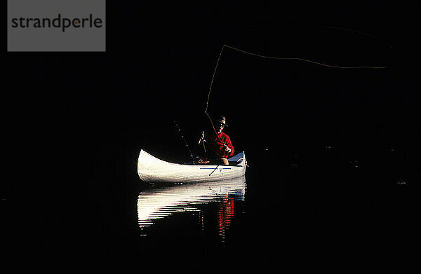 A man on a canoe on a lake  Alaska  USA.