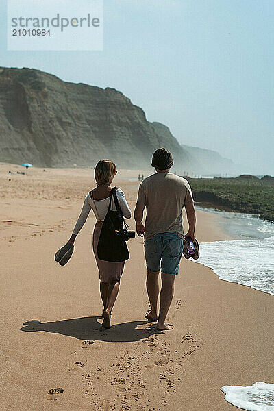 Happy friends walking on the beach.