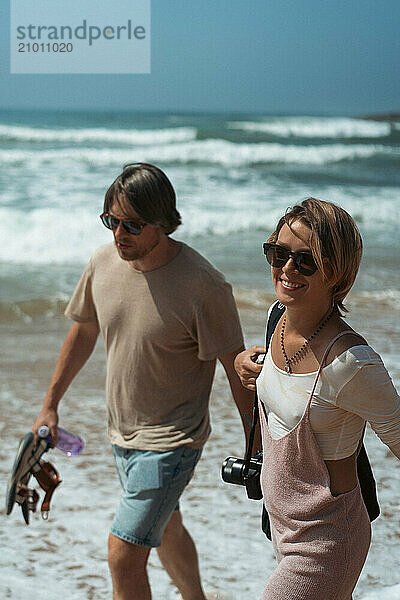 Happy friends walking on the beach.