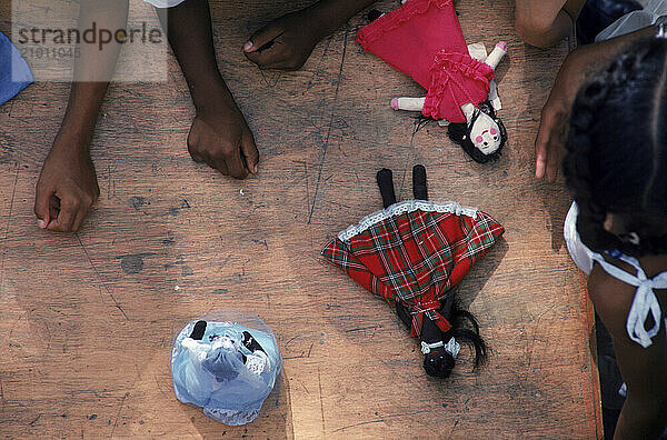 Young children playing with dolls on the floor  Cuba.