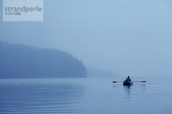 A small row boat on calm waters in Southeast Alaska.