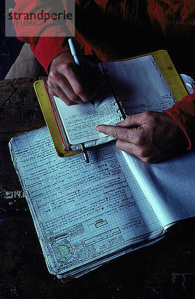 A man making notes about the tides  Alaska  USA.