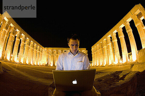 A tourist picks up a local Internet connection in the middle of the famed Luxor Temple in Egypt