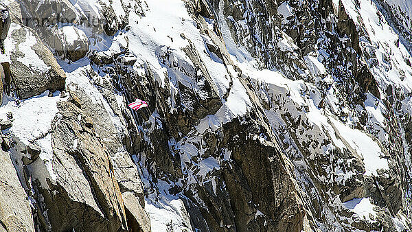 A Person Flying In A Wing Suit Against A Backdrop Of Sheer Rocky Cliff