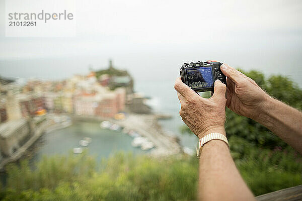 Man photographing town below  Â Vernazza  Liguria  Italy