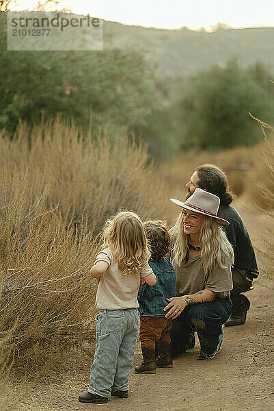 Family on nature trail looks at flowers