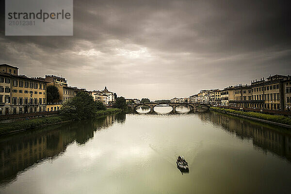 A boat moves up the Arno River in Florence  Italy.