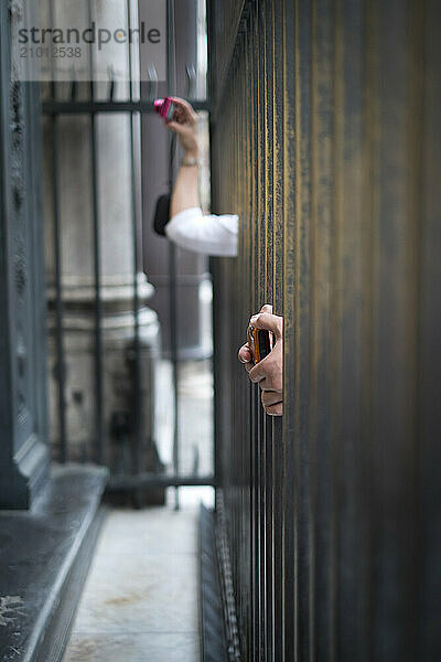 Hands with cameras crane to photograph Ghiberti's Doors on the Baptistry in Florence  Italy.