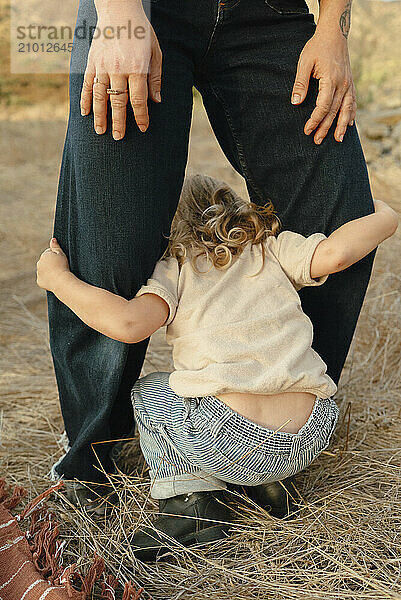 Child playing between moms legs