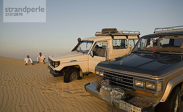 Two local Egyptians relax near their SUVs near El-Siwa  Egypt