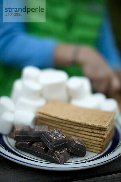 Marshmallows  graham crackers  and chocolate make up smores ingredients for camping.