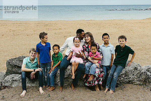 Diverse family with many children smile together on beach