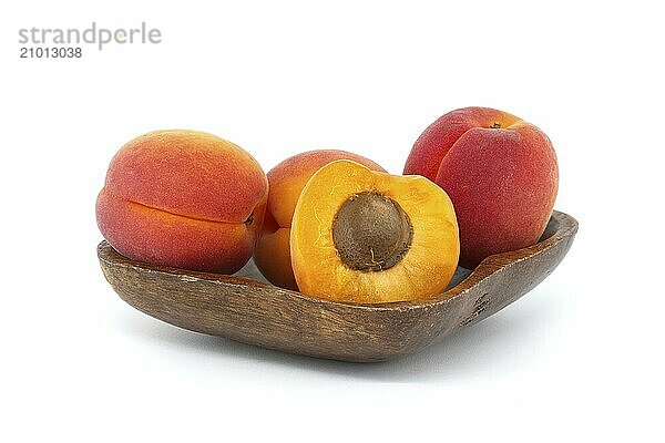 Collection of ripe whole apricots and one cut in half to reveal its interior  isolated on a white background